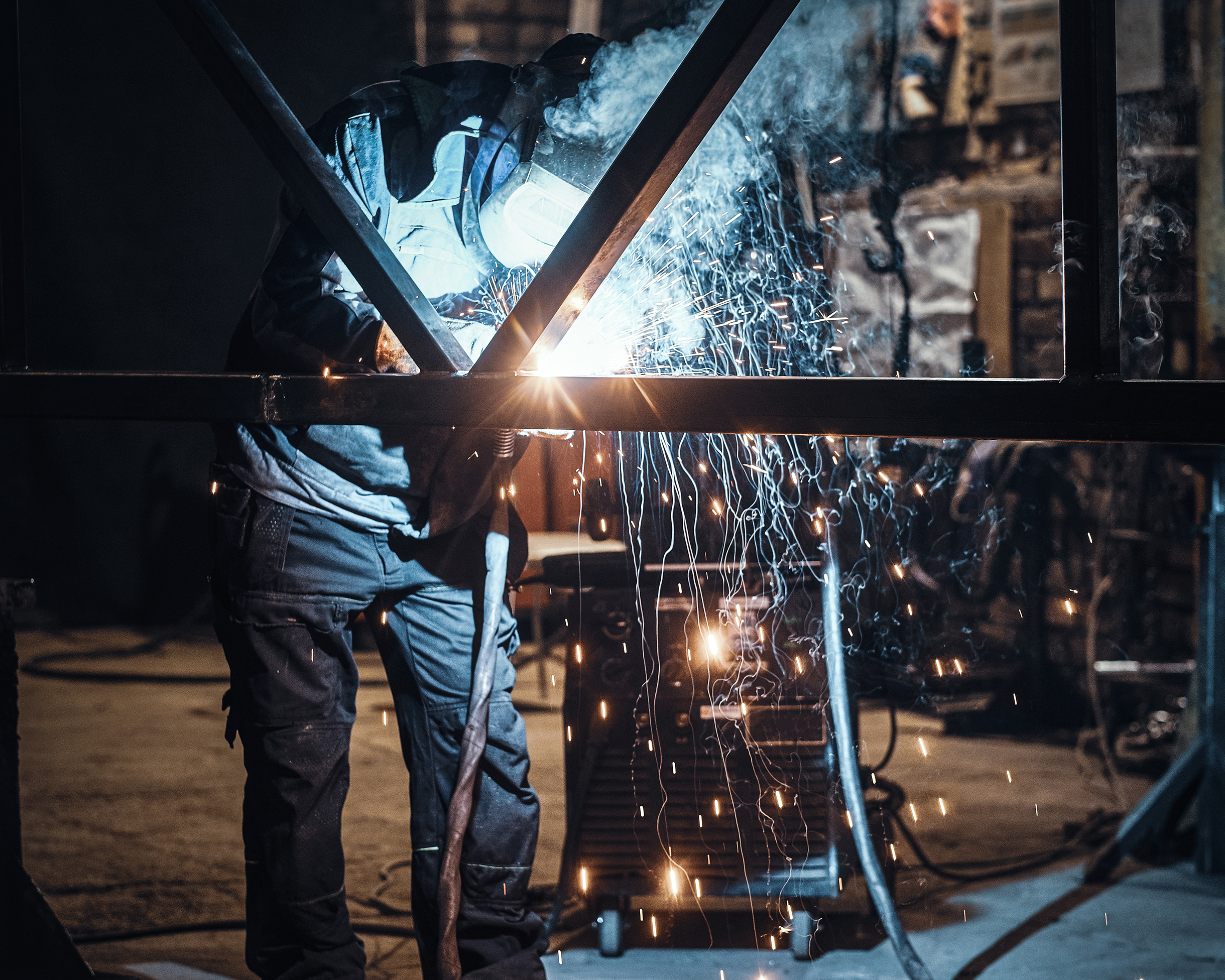 Welding work with metal construction at busy metal factory